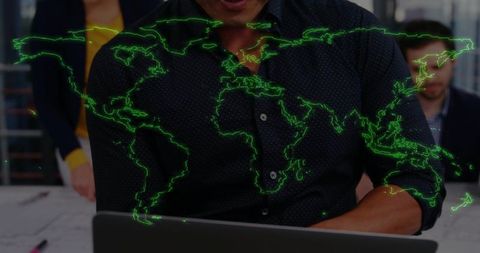 Asian man working on laptop with holographic green world map overlay in modern office