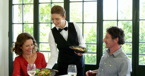 Smiling Waitress Serving Couple in Bright Restaurant - Download Free Stock Images Pikwizard.com
