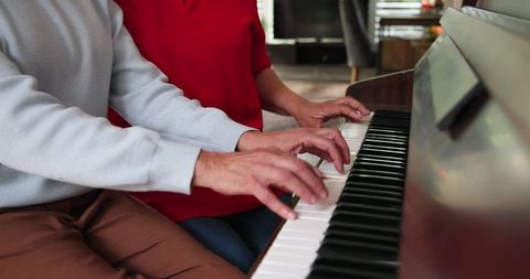 Senior Mother and Daughter Playing Piano Together at Home