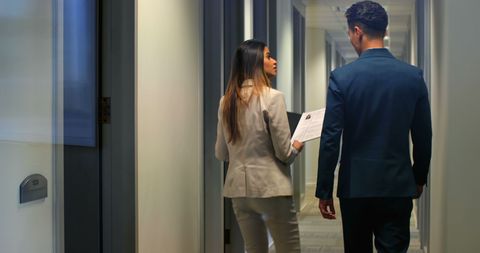 Two Business Professionals Conversing in Office Hallway