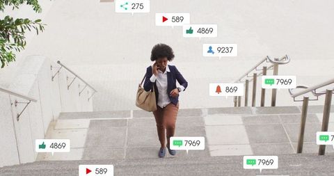 Professional woman walking up city steps checking smartphone with floating social media notification