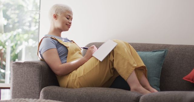 Young Woman Journaling on Sofa in Cozy Living Room - Download Free Stock Images Pikwizard.com