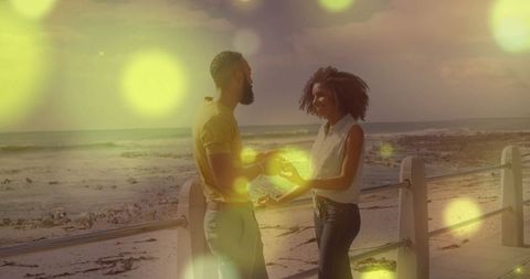 Couple sharing romantic moment on seaside promenade at sunset