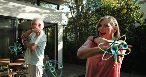 Active seniors stretching on backyard patio with augmented reality fitness overlays at home