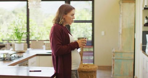 Pregnant Woman Relaxing in Kitchen with Tea as Sunlight Streams In - Download Free Stock Images Pikwizard.com