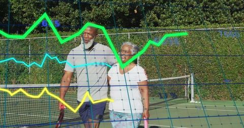 Mature Couple with Tennis Racquets on Active Outdoor Leisure Walk