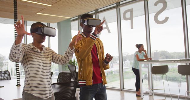 Group of colleagues using VR headsets in a modern office space. Perfect for depicting themes of technology in the workplace, innovation, and professional collaboration. Useful for tech industry blogs, business websites, promotional material for new technology, or articles about modern office environments.