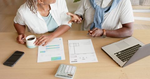 Senior Couple Discussing Household Finances at Home Table