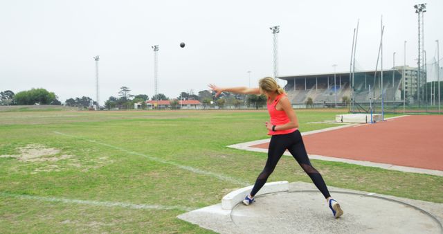 Rear view of Caucasian female athlete practicing shot put throw at sports venue. She is standing at sports venue 4k