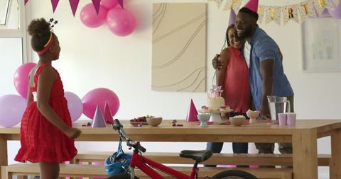 Happy family celebrating birthday with surprises at home