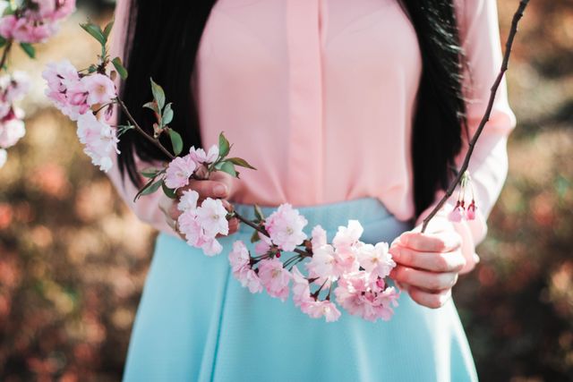 Woman Holding Cherry Blossom Branch Outdoors - Download Free Stock Photos Pikwizard.com