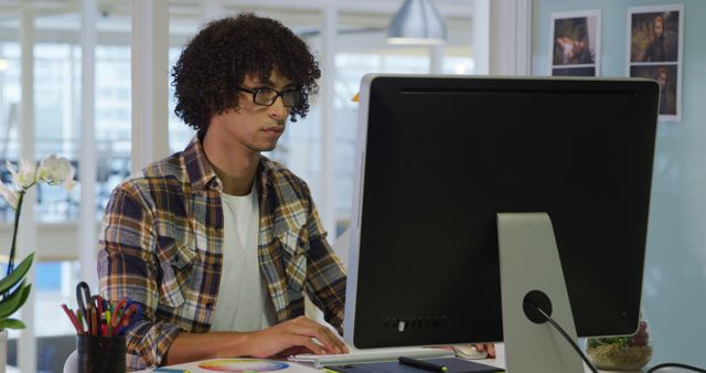 Young man working in design office on desktop computer - Download Free Stock Images Pikwizard.com