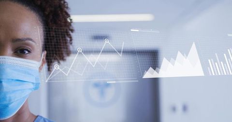 Nurse wearing surgical mask viewing digital healthcare analytics overlays in hospital corridor