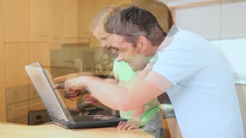 Father and Daughter Exploring Laptop in Modern Kitchen