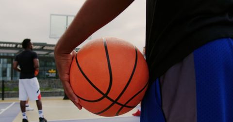 Close-Up of Basketball Player Holding Ball on Outdoor Court