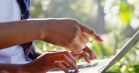 Close-Up of Hands Typing on Laptop in Park Setting