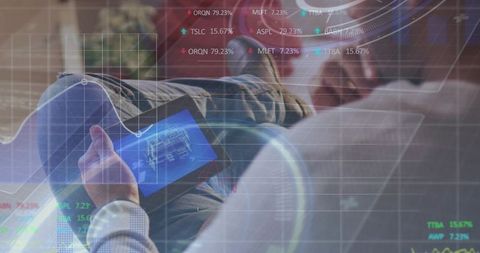 Reclining man holding tablet with HUD overlays showing blueprint and data analytics