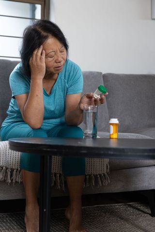 Senior Asian Woman Checking Medicine at Home