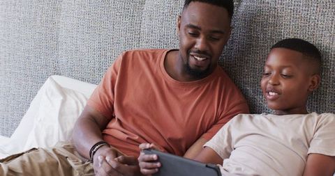 Father and Son Bonding Over Tablet in Comfortable Home Space