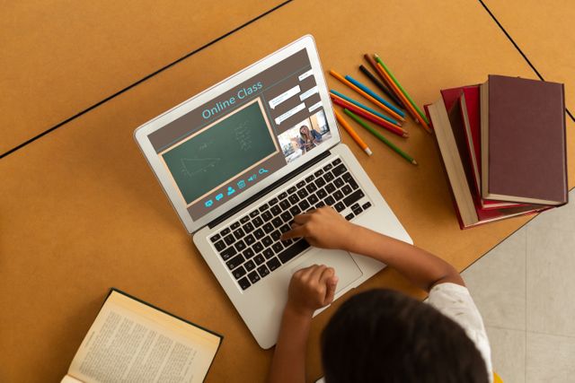 Child engaging in online education through a laptop. Useful for online learning, homeschooling programs, educational websites, e-learning platforms, and remote education resources.