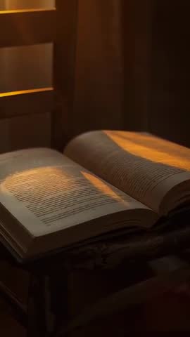 Sunlight Sliding Across Open Hardcover Book on Wooden Stool Near Window | Vertical Video
