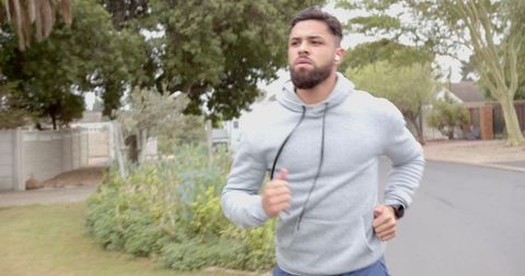 Hispanic male jogging in suburban neighborhood