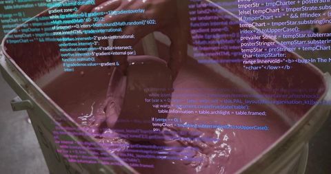Gloved technician stirring thick purple industrial pigment in container with code overlay