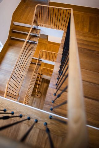 Spiral view of wooden staircase with baldotta handrail design