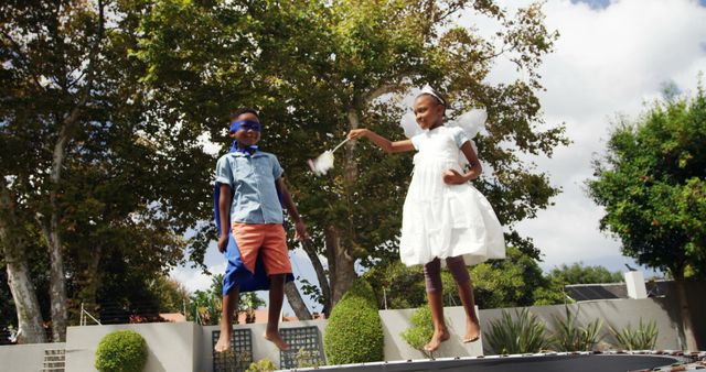 Kids Enjoying Time on Trampoline with Magic Wand Outdoors - Download Free Stock Images Pikwizard.com