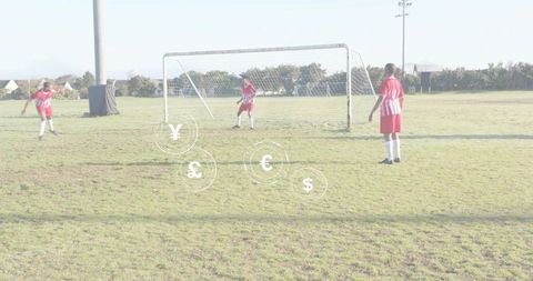 Youth soccer defenders lining up by goal with floating currency symbols sponsorship concept