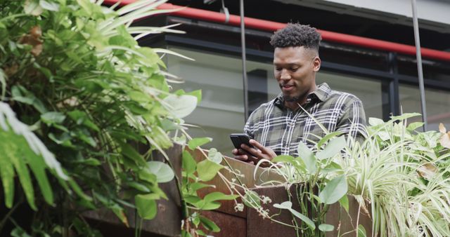 Happy Man Relaxing with Smartphone in Modern Urban Garden - Download Free Stock Images Pikwizard.com