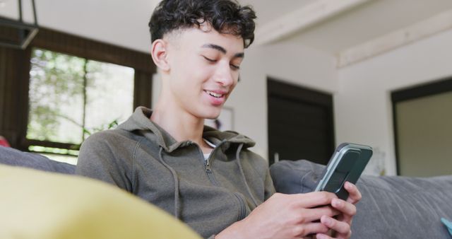 Teenager Smiling While Using Smartphone at Home - Download Free Stock Images Pikwizard.com