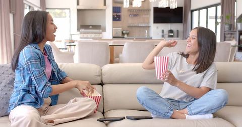 Teenagers Enjoying Different Flavored Popcorn on Comfortable Couch