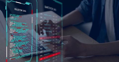IT professional analyzing holographic data dashboard while coding on laptop and smartphone