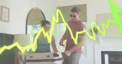 Couple packing suitcase at home with neon financial wave overlay concept for travel