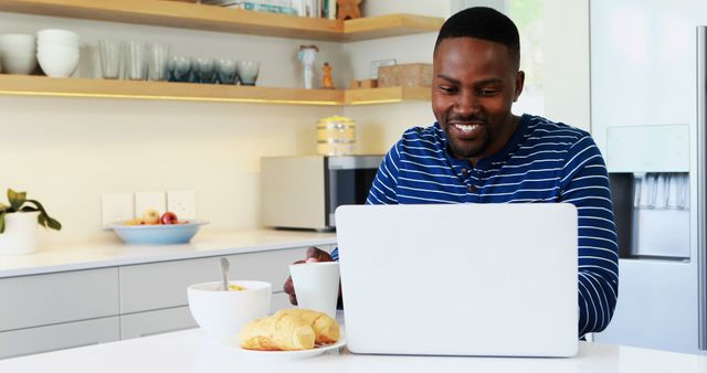 Man Having Breakfast While Working on Laptop at Home Kitchen - Download Free Stock Images Pikwizard.com