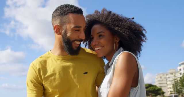 Romantic diverse couple embracing and smiling on sunny promenade, copy space. Summer, vacation, romance, love, relationship, free time and lifestyle, unaltered.