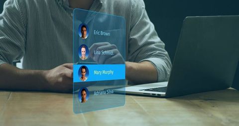 Working man interacting with holographic contact list over laptop highlighting Mary Murphy