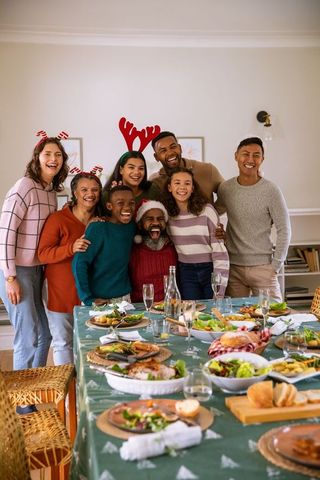 Diverse family celebrating holiday around festive table