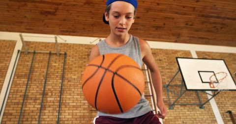 Teenage basketball player practicing indoor dribbling skills
