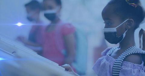 Students wearing face masks engaging with interactive displays in classroom