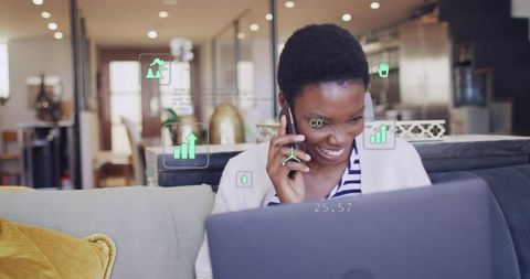 Smiling woman working remotely using laptop and smartphone with ar analytics overlay