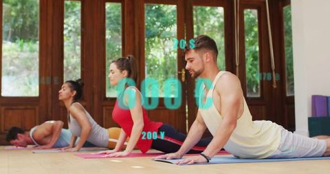 Group Practicing Upward Facing Dog In Yoga Studio