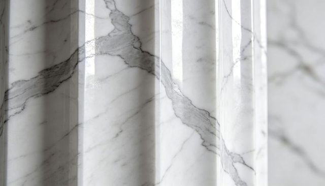 Polished white marble fluted column reflecting light with diagonal grey veins