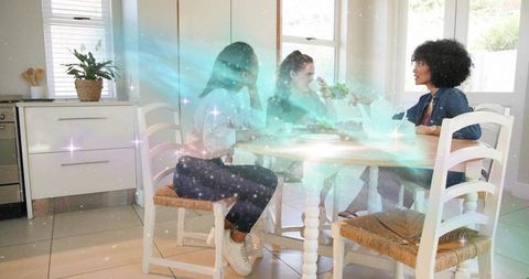 Three friends chatting around sunlit kitchen table with turquoise nebula overlay