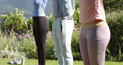 African american friends stretching on lawn wearing sportswear for outdoor fitness