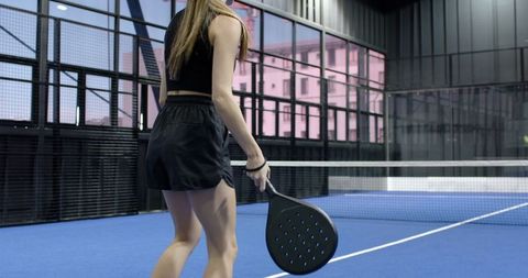 Woman Holding Padel Racket on Indoor Court Preparing for Game