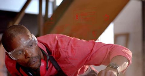 Carpenter securing beam during home renovation wearing safety goggles and ear protection