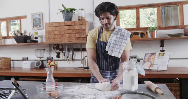 Man kneading dough in home kitchen with tablet - Download Free Stock Images Pikwizard.com