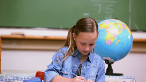 Young Student Learning Happily at School Desk with Globe